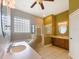 Bathroom with a jacuzzi tub, a large window, and a glass shower at 1224 Shorecrest Cir, Clermont, FL 34711