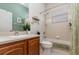 Well-lit bathroom with a wooden vanity, integrated sink, and a shower-tub combination with floral shower curtains at 1224 Shorecrest Cir, Clermont, FL 34711