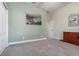 Spacious carpeted bedroom featuring modern wall art, an oak dresser, and a doorway to an adjoining room at 1224 Shorecrest Cir, Clermont, FL 34711