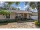 Inviting single-story home featuring manicured landscaping, a red front door, and a two-car garage at 1224 Shorecrest Cir, Clermont, FL 34711