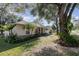 Charming single-story home boasts a lush landscaped yard with mature trees and a cozy, inviting facade at 1224 Shorecrest Cir, Clermont, FL 34711