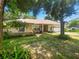 Charming single-story home boasts a lush landscaped yard with mature trees and a cozy, inviting facade at 1224 Shorecrest Cir, Clermont, FL 34711