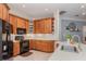 Well-equipped kitchen featuring wooden cabinets, modern black appliances, and recessed lighting at 1224 Shorecrest Cir, Clermont, FL 34711