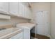 Functional laundry room with ample cabinet space and a utility sink for added convenience at 1224 Shorecrest Cir, Clermont, FL 34711