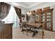 Elegant dining room featuring a chandelier, a wooden table, and built-in display cabinets at 1246 Pallister Ln, Lake Mary, FL 32746