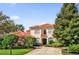 Charming two-story home with a red tile roof, lush landscaping, and a long driveway at 1246 Pallister Ln, Lake Mary, FL 32746