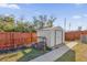 View of the shed in the backyard with a privacy fence, green space, and concrete walkway at 13258 Sw 29Th Cir, Ocala, FL 34473