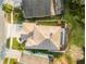 Aerial view of home with screened-in pool, well-maintained landscaping, and neutral-toned roof at 13631 Guildhall Cir, Orlando, FL 32828