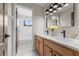 Modern bathroom boasts double vanity with light wood cabinets, marble countertop and matte black fixtures at 13631 Guildhall Cir, Orlando, FL 32828