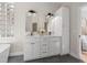 Bathroom with a double vanity featuring marble countertops, modern fixtures, and built-in storage at 13631 Guildhall Cir, Orlando, FL 32828