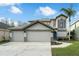 Front exterior of home with a three-car garage, well-manicured landscaping, and ample driveway space at 13631 Guildhall Cir, Orlando, FL 32828