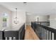 Hallway features a wood floor, black railings, and a decorative light fixture at 13631 Guildhall Cir, Orlando, FL 32828