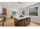 Bright kitchen features stainless steel appliances, island with a white countertop, and wood cabinets at 13631 Guildhall Cir, Orlando, FL 32828