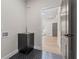 Functional laundry area with utility sink, black and white patterned floors, and access to hallway at 13631 Guildhall Cir, Orlando, FL 32828