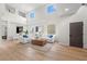 Sunlit living room with vaulted ceilings, hardwood floors, stylish seating and decor, and neutral colors at 13631 Guildhall Cir, Orlando, FL 32828