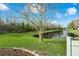 Backyard view of the pond with lush green lawn and mature landscaping at 13631 Guildhall Cir, Orlando, FL 32828