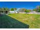 View of the expansive backyard featuring mature trees, a metal storage building, and lush lawn at 14 E Cypress St, Davenport, FL 33837