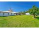 Spacious backyard with lush green grass, a storage building, and the home's exterior featuring a tiled roof at 14 E Cypress St, Davenport, FL 33837