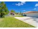 Wide driveway leading to a two-car garage, with a storage building, fenced yard, and a glimpse of the home at 14 E Cypress St, Davenport, FL 33837