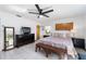 Serene main bedroom featuring tile floors, dresser, TV, and lots of bright, natural light at 14 E Cypress St, Davenport, FL 33837