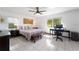 Bright main bedroom featuring tile floors, desk, ceiling fan, and lots of natural light at 14 E Cypress St, Davenport, FL 33837