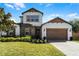 Charming two-story home with stone accents, landscaped yard, and attached two-car garage at 14101 Creekbed Cir, Winter Garden, FL 34787