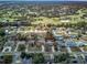 Aerial view of neighborhood homes with mature landscaping and a golf course in the distance at 1433 Ne Old Mill Dr, Deltona, FL 32725