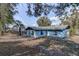 Backyard view of the home's exterior and perimeter fence and mature landscaping at 1433 Ne Old Mill Dr, Deltona, FL 32725