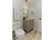 Bathroom featuring a grey vanity with gold hardware and wood-look flooring at 1433 Ne Old Mill Dr, Deltona, FL 32725