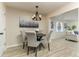 Cozy dining area with modern chandelier, wood-look flooring, and elegant gray upholstered chairs at 1433 Ne Old Mill Dr, Deltona, FL 32725