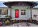 Inviting entrance to a well-kept home with vibrant landscaping and a striking red front door at 1433 Ne Old Mill Dr, Deltona, FL 32725