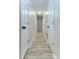 Hallway with white doors, neutral walls, and wood-look flooring at 1433 Ne Old Mill Dr, Deltona, FL 32725