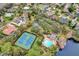 An aerial view of community amenities including a tennis court, basketball court, swimming pool, and mature trees at 14851 Oldham Dr, Orlando, FL 32826