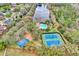 An aerial view showing a community pool, tennis courts, and basketball court next to a lake surrounded by lush greenery at 14851 Oldham Dr, Orlando, FL 32826