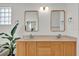 Bathroom featuring double vanity with natural lighting, modern fixtures and neutral tile flooring at 14851 Oldham Dr, Orlando, FL 32826