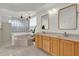 Bathroom featuring double vanity with a large soaking tub and decorative lighting at 14851 Oldham Dr, Orlando, FL 32826