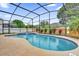 Screened-in pool with a hot tub surrounded by well-maintained landscaping at 14851 Oldham Dr, Orlando, FL 32826