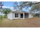 Exterior back of the home featuring a screened-in porch and a well-manicured lawn at 15318 Harvest Blvd, Clermont, FL 34714