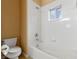 Clean bathroom features white tile, a bathtub, and a window for natural light at 15318 Harvest Blvd, Clermont, FL 34714