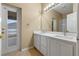 Bathroom with double vanity, granite counters, white cabinets, and neutral colors at 15318 Harvest Blvd, Clermont, FL 34714