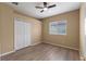 Well-lit bedroom features wood floors, neutral walls, a ceiling fan, and a large closet at 15318 Harvest Blvd, Clermont, FL 34714