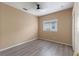 Cozy bedroom with light wood floors, neutral walls, ceiling fan, and natural light at 15318 Harvest Blvd, Clermont, FL 34714