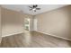 This bedroom features light hardwood floors, a ceiling fan, and a bathroom and door off to the side at 15318 Harvest Blvd, Clermont, FL 34714