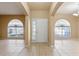 Foyer with tile flooring and arched entryways to the living areas, featuring neutral paint throughout at 15318 Harvest Blvd, Clermont, FL 34714