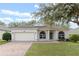 Charming one-story home with a manicured lawn, brick paver driveway and an attached two-car garage at 15318 Harvest Blvd, Clermont, FL 34714