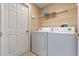 Laundry room with a washer, dryer, tile flooring, and white walls at 15318 Harvest Blvd, Clermont, FL 34714