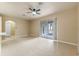 Spacious living room with a ceiling fan, neutral paint, tile flooring, and sliding glass doors to the lanai at 15318 Harvest Blvd, Clermont, FL 34714