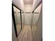 Hallway with mirrored closet doors and light wood flooring, leading to white doors at 155 S Court Ave # 1705, Orlando, FL 32801