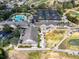 An aerial view of a clubhouse, pool area, and parking facilities, set within a well-kept community at 15705 Sw 16Th Ter, Ocala, FL 34473