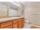 Well-lit bathroom with neutral walls, wood cabinet, sink, mirror, toilet, and shower at 15705 Sw 16Th Ter, Ocala, FL 34473